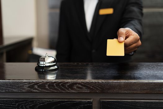male receptionist suit offering room key