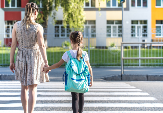 Back to school education concept with girl kids, elementary students, carrying backpacks going to class on school first day holding hand in hand together walking up building stair happily