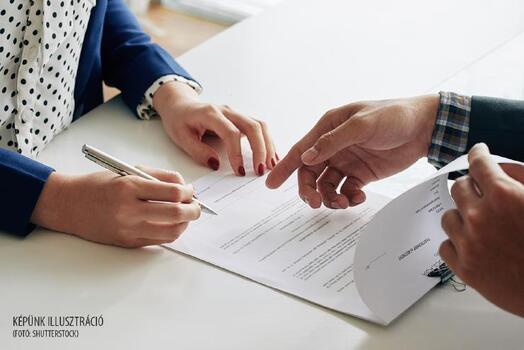Businessman showing female partner where to sign agreement