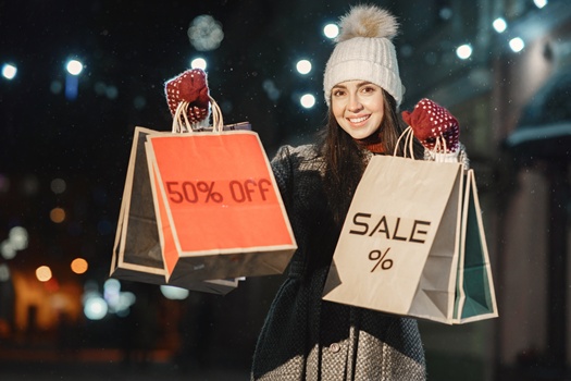 Shopping conception. Outdoor night portrait of young girl. Posing in street of European city.