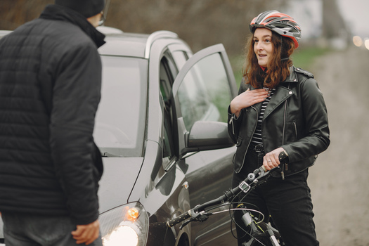 The woman crashed into the car. Girl in a helmet. People quarrel over the accident.