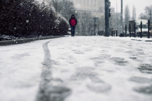 low angle shot person walking snow covered sidewalk snow