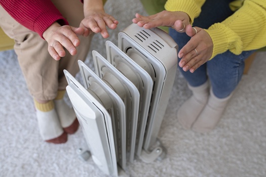 high angle people getting warm near heater