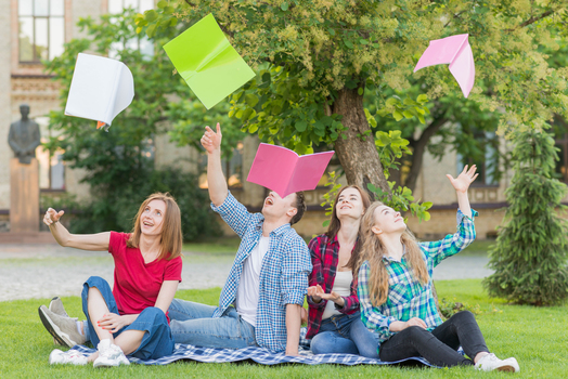 group students throwing books air