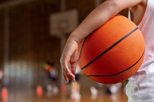 schoolboy with basketball standing basketball court