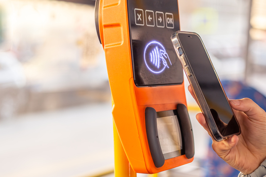 Paying for public transport by card. Public transport. Contactless fare payment. High quality photo. Copy space. Public transportation and people concept. Woman buying ticket via digital wallet.